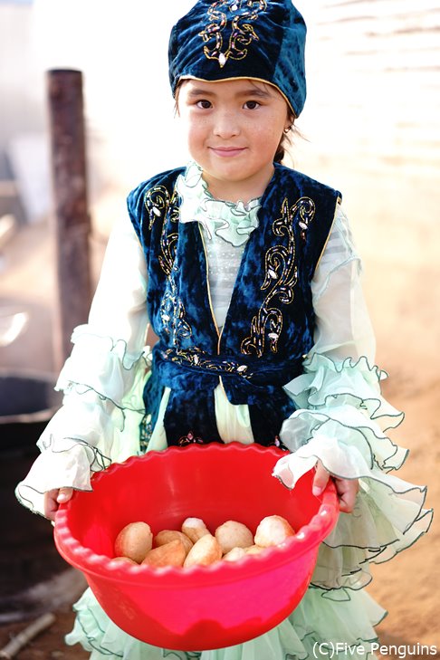 バウルサク（揚げパン）を持つカザフ族の女の子