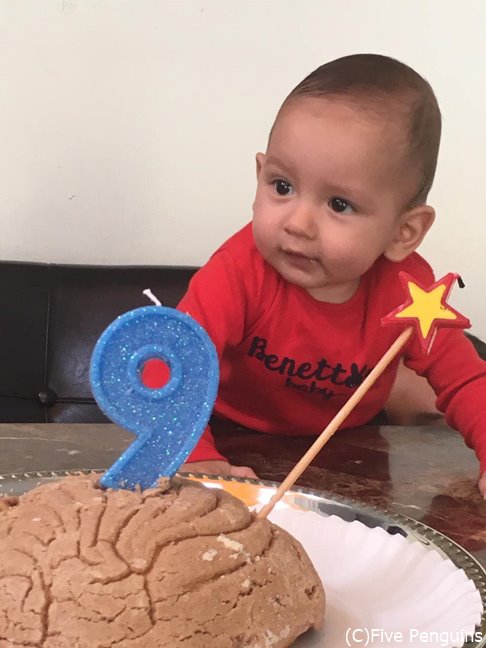 コンチャをケーキに見立てて誕生祝をする赤ちゃん