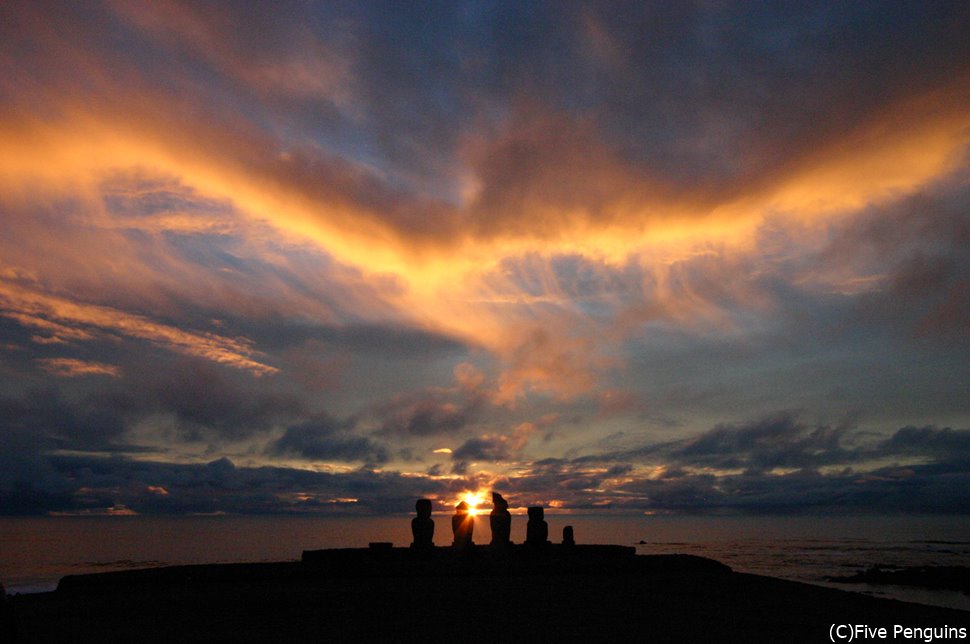 イースター島・タハイ儀式村のアフ・バイ・ウリの遠くに沈む夕陽