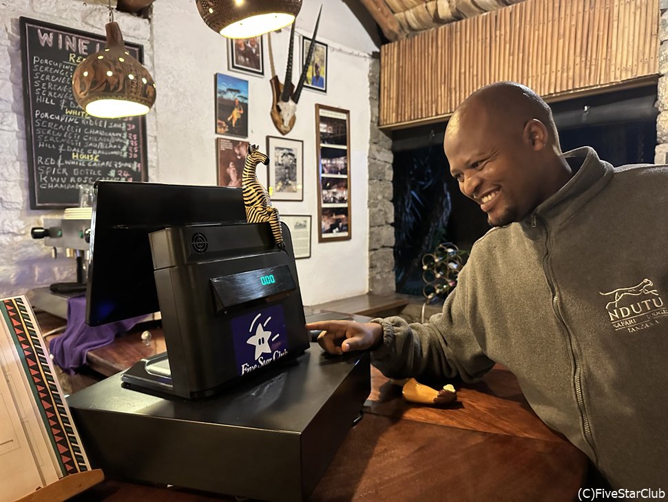 ホテルのバーでファイブスターのステッカーを見て微笑むフレンドリーなスタッフ